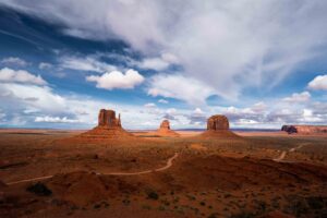 Monument Valley landscape with towering sandstone formations under a dramatic cloudy sky